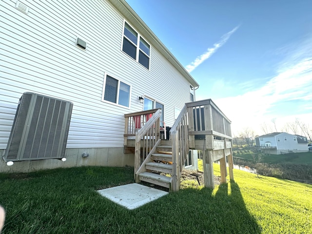 rear view of house with a lawn and central air condition unit