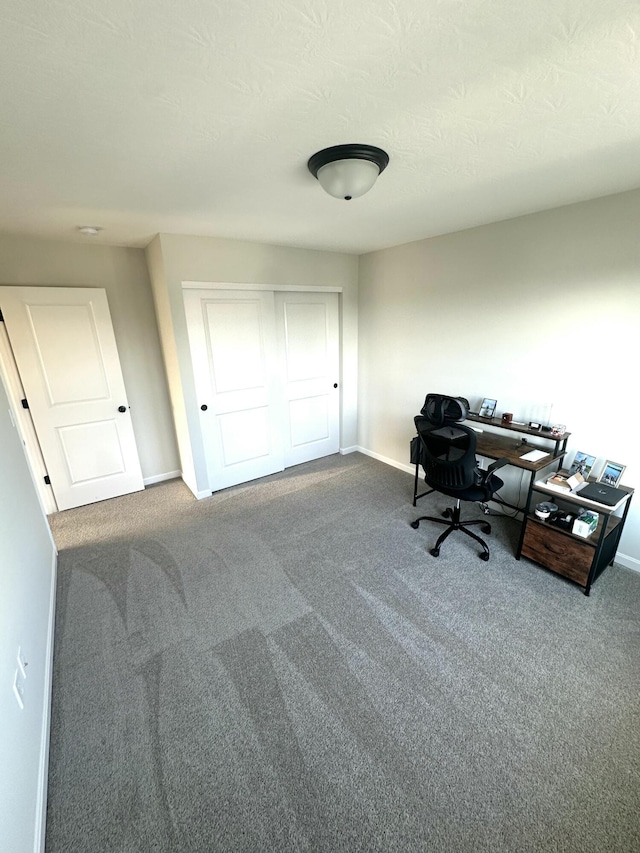 carpeted office featuring a textured ceiling