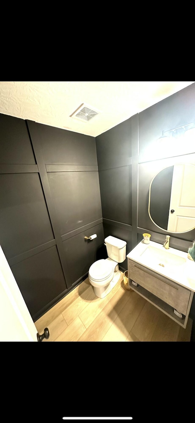 bathroom featuring vanity, hardwood / wood-style floors, and toilet