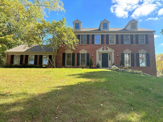 colonial inspired home featuring a front lawn