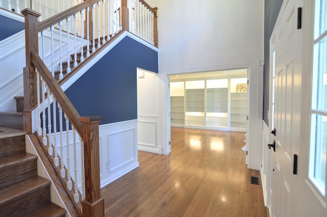 foyer entrance with a high ceiling and wood-type flooring