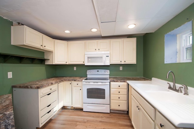 kitchen with sink, white appliances, and light hardwood / wood-style flooring