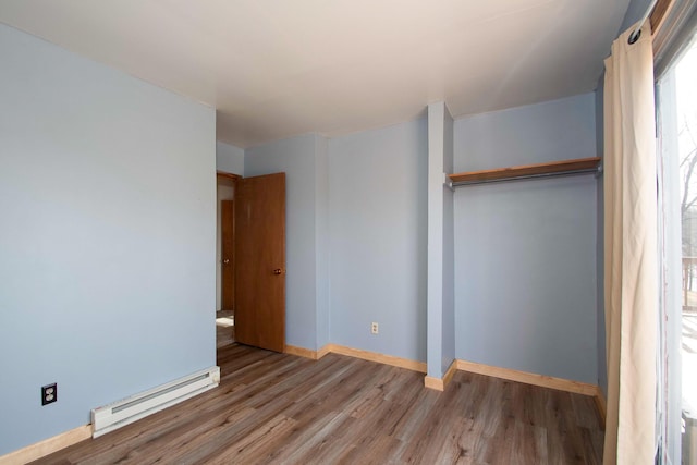 unfurnished bedroom featuring a baseboard radiator and light hardwood / wood-style floors