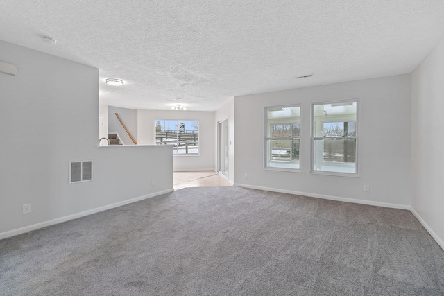 unfurnished living room with light carpet and a textured ceiling