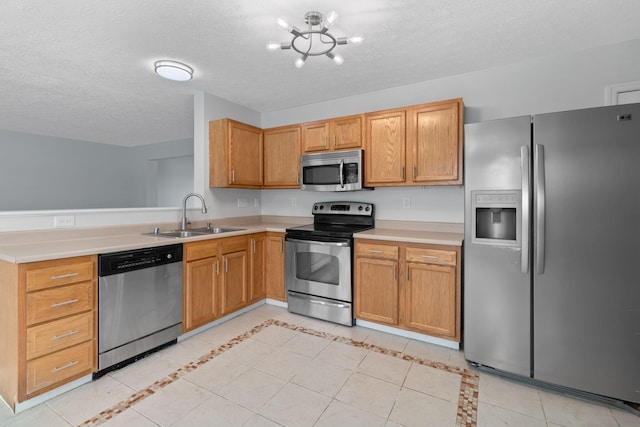 kitchen with stainless steel appliances, sink, and a textured ceiling