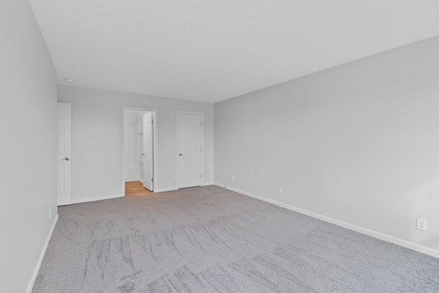 carpeted empty room featuring a textured ceiling