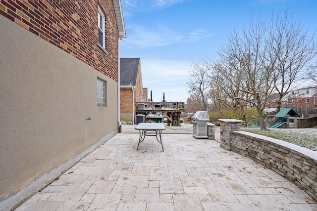 view of patio / terrace with a wooden deck and a playground