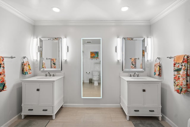 bathroom with ornamental molding, vanity, and toilet