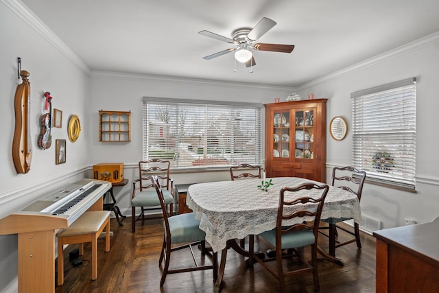 dining space featuring crown molding, dark wood-type flooring, and ceiling fan