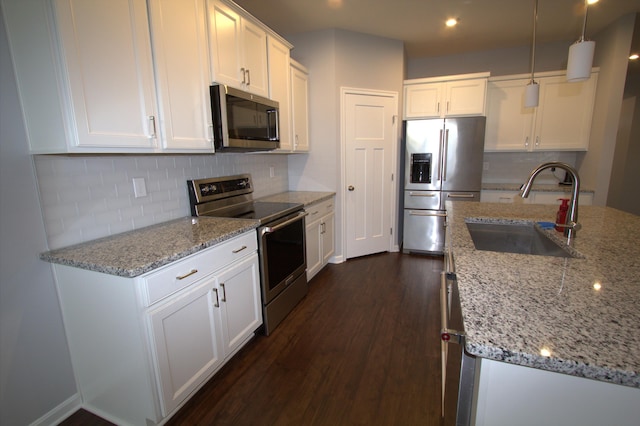 kitchen with decorative backsplash, stainless steel appliances, dark wood-style floors, white cabinetry, and a sink