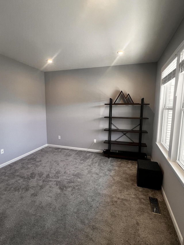 spare room with visible vents, carpet, and baseboards