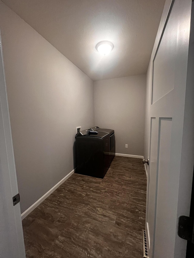 laundry room featuring baseboards, separate washer and dryer, dark wood-style flooring, and laundry area