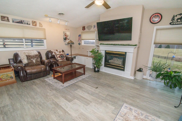 living room with ceiling fan, lofted ceiling, and light wood-type flooring