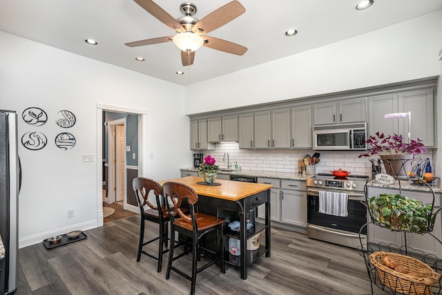 kitchen featuring backsplash, gray cabinets, stainless steel appliances, and dark hardwood / wood-style floors