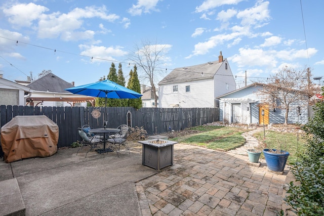 view of patio with grilling area, an outdoor fire pit, and a storage unit