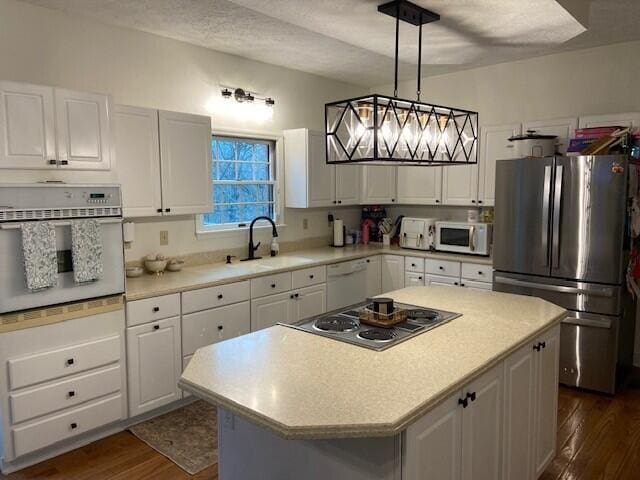 kitchen featuring pendant lighting, a center island, white cabinets, and appliances with stainless steel finishes