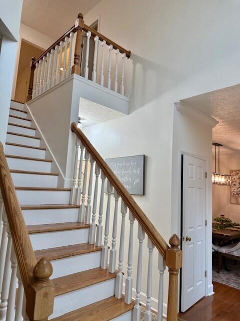 staircase with hardwood / wood-style flooring and a textured ceiling