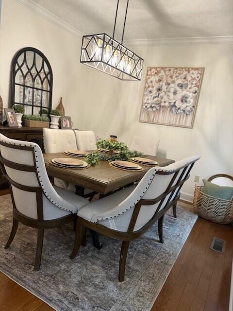 dining room with ornamental molding and wood-type flooring