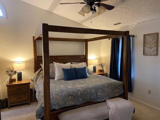 carpeted bedroom featuring lofted ceiling, ceiling fan, and a textured ceiling