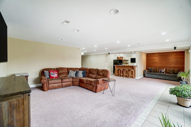 living room featuring light colored carpet and wood walls