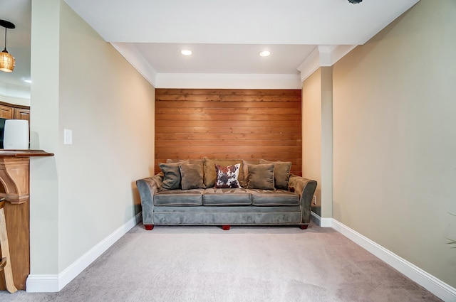 living room featuring ornamental molding, wooden walls, and light colored carpet