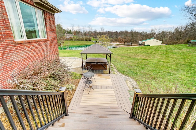 exterior space with a gazebo, a lawn, a hot tub, and a water view