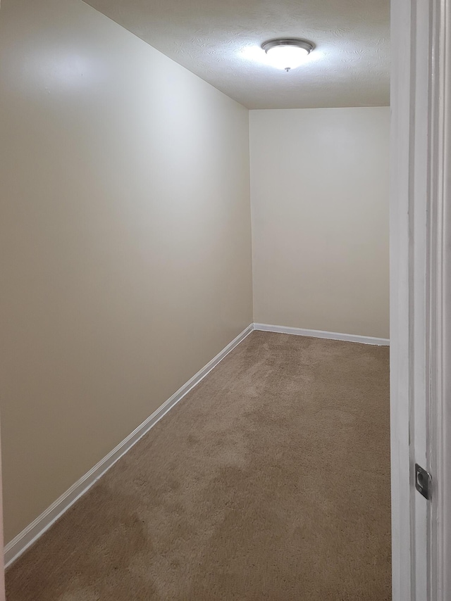 spare room with a textured ceiling and carpet