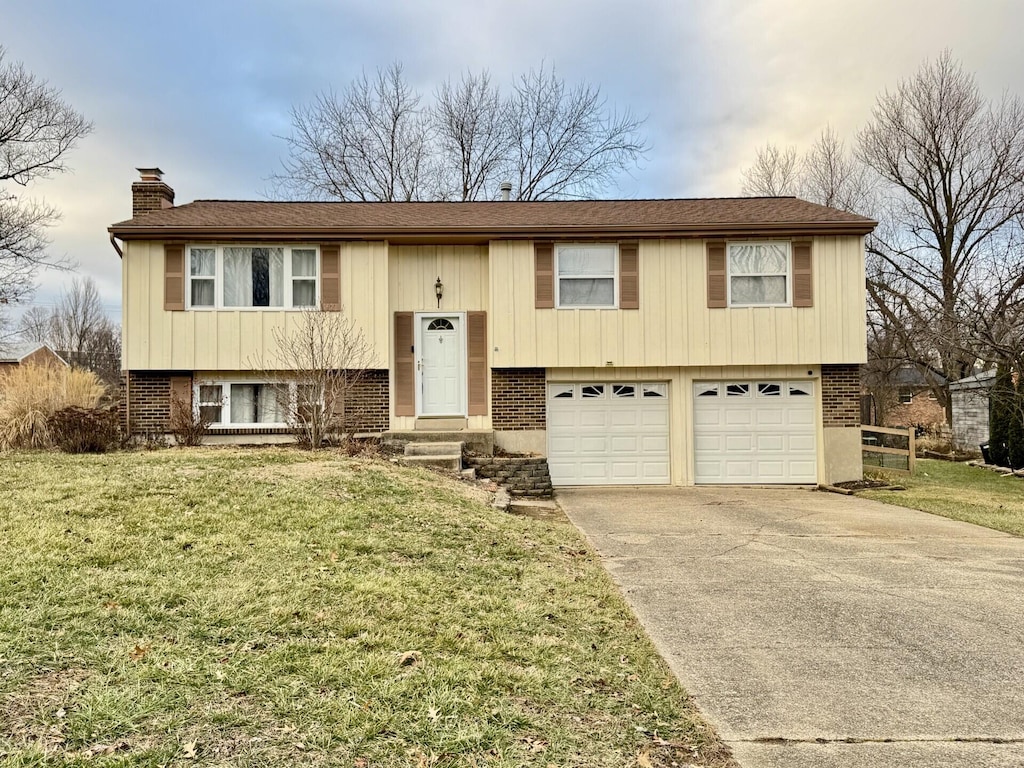 raised ranch with a garage and a front lawn