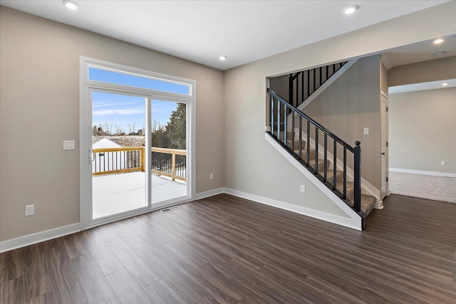 spare room featuring stairs, dark wood-style flooring, recessed lighting, and baseboards