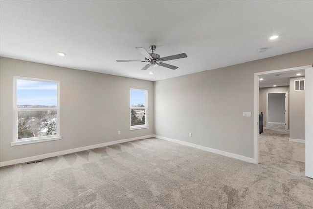 unfurnished room with light colored carpet, visible vents, baseboards, and recessed lighting