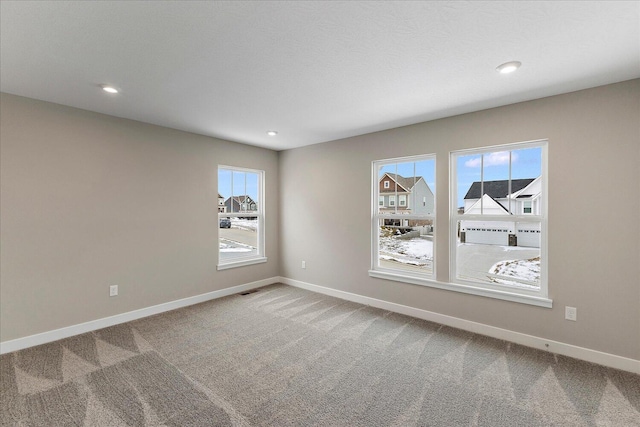 carpeted empty room featuring recessed lighting and baseboards