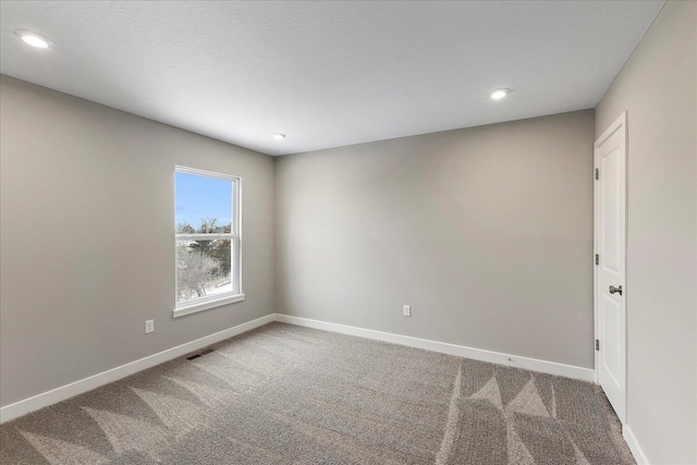 carpeted spare room with recessed lighting, visible vents, and baseboards