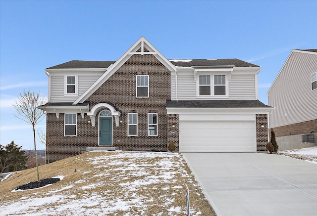 traditional-style home featuring a garage, driveway, brick siding, and a shingled roof