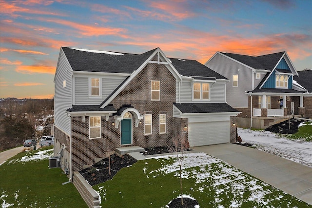 view of front of house featuring driveway, a garage, a yard, central AC, and brick siding