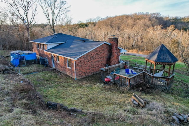 view of side of home with a gazebo, central AC, and a deck