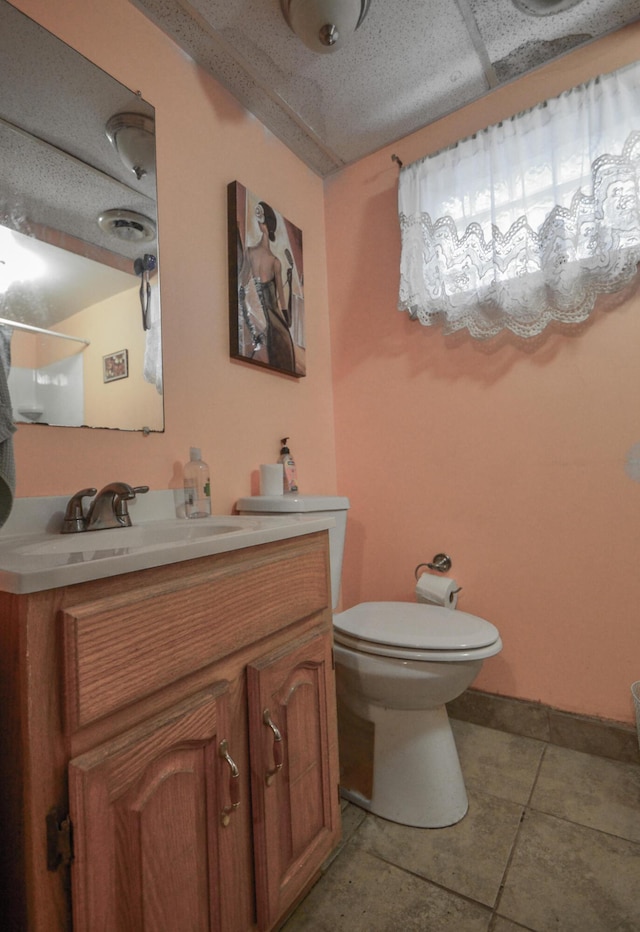 bathroom featuring tile patterned floors, vanity, and toilet