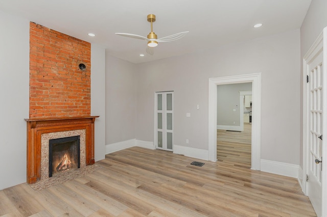 unfurnished living room featuring ceiling fan and light wood-type flooring