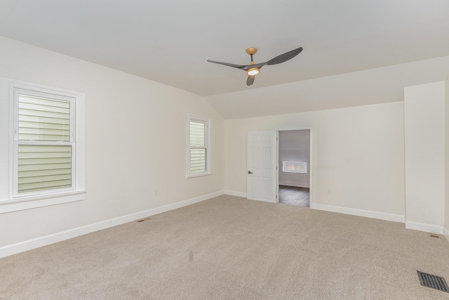 carpeted empty room with ceiling fan and vaulted ceiling