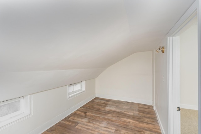 bonus room with vaulted ceiling and dark hardwood / wood-style flooring