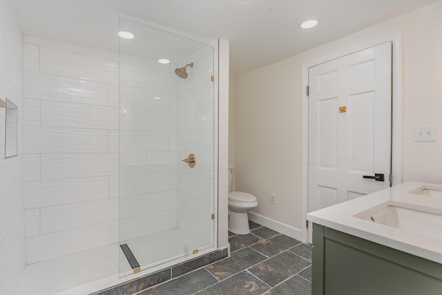 bathroom featuring vanity, toilet, and a tile shower