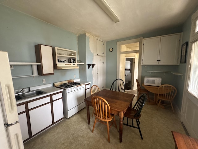 kitchen with white cabinetry, sink, and white appliances