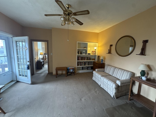 living room with ceiling fan and carpet