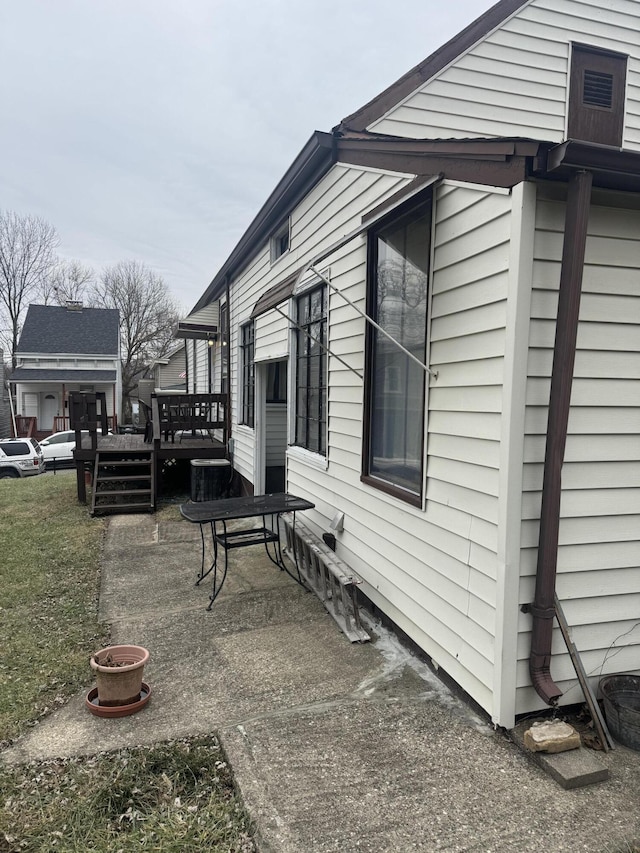 view of property exterior with a patio and a deck