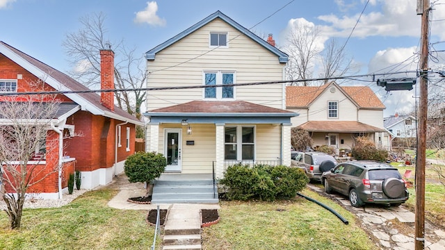 front facade featuring covered porch and a front lawn