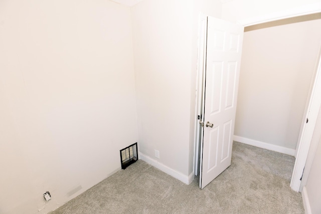 laundry area featuring light carpet