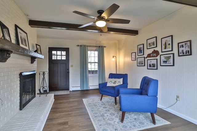 living area with beam ceiling, dark hardwood / wood-style flooring, and a baseboard heating unit