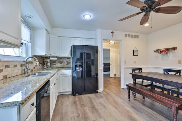 kitchen with white cabinetry, light stone countertops, sink, and black appliances