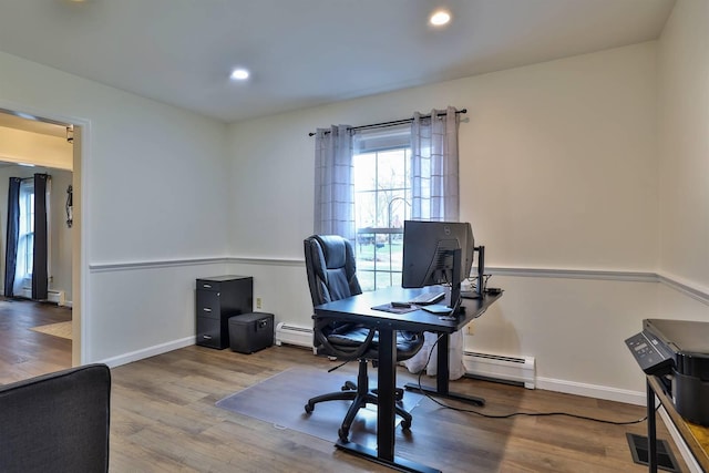 office area featuring a baseboard heating unit and hardwood / wood-style floors