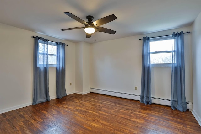 spare room featuring baseboard heating, ceiling fan, and dark hardwood / wood-style floors