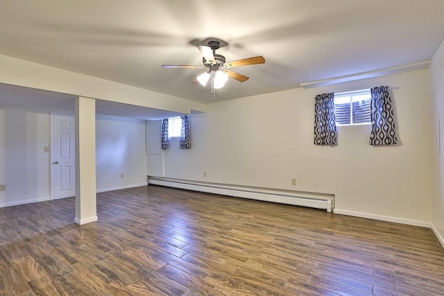 basement featuring a baseboard heating unit, dark wood-type flooring, and ceiling fan